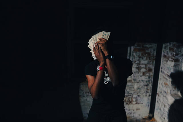 RodSlime fanning cash in a dark room.