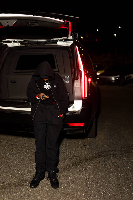 RodSlime standing at the open tailgate of an SUV at night.