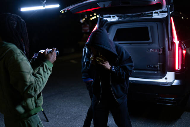 RodSlime and crew at the back of an SUV under teal and red light.